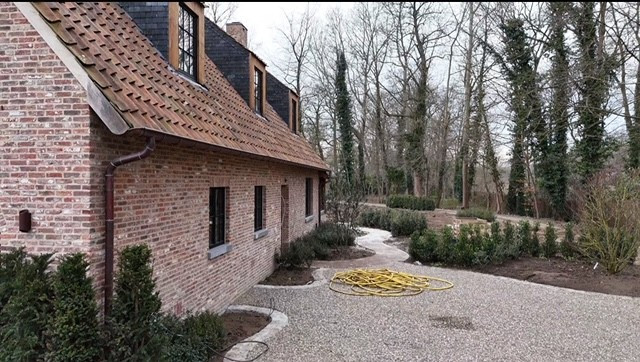 aanleg van terras en oprit in half verharding bij landelijke woning in oost-vlaanderen
